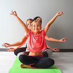 Mädchen sitzen hintereinander und machen Yoga